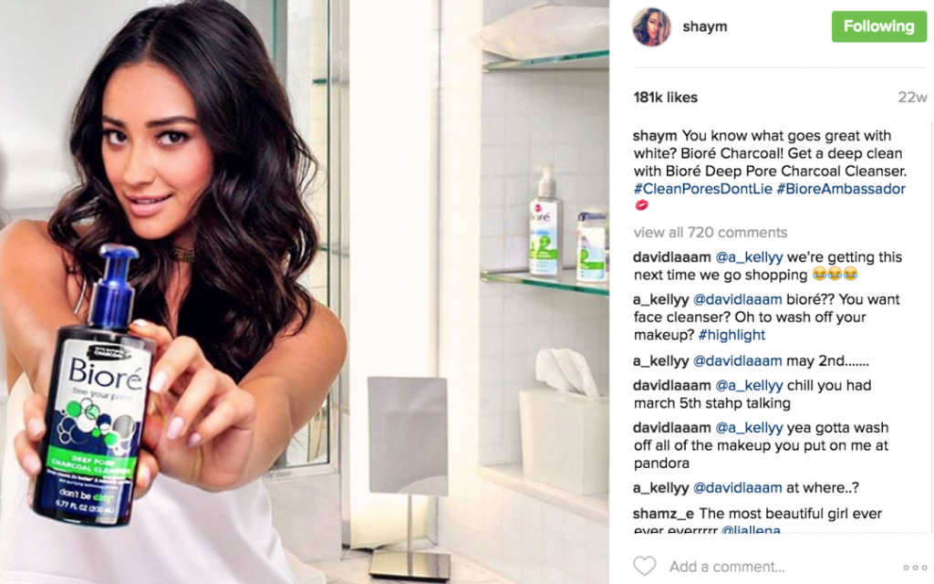 Instagram model showing Biore Deep Pore Charcoal Cleanser product, smiling in the background while holding product. 